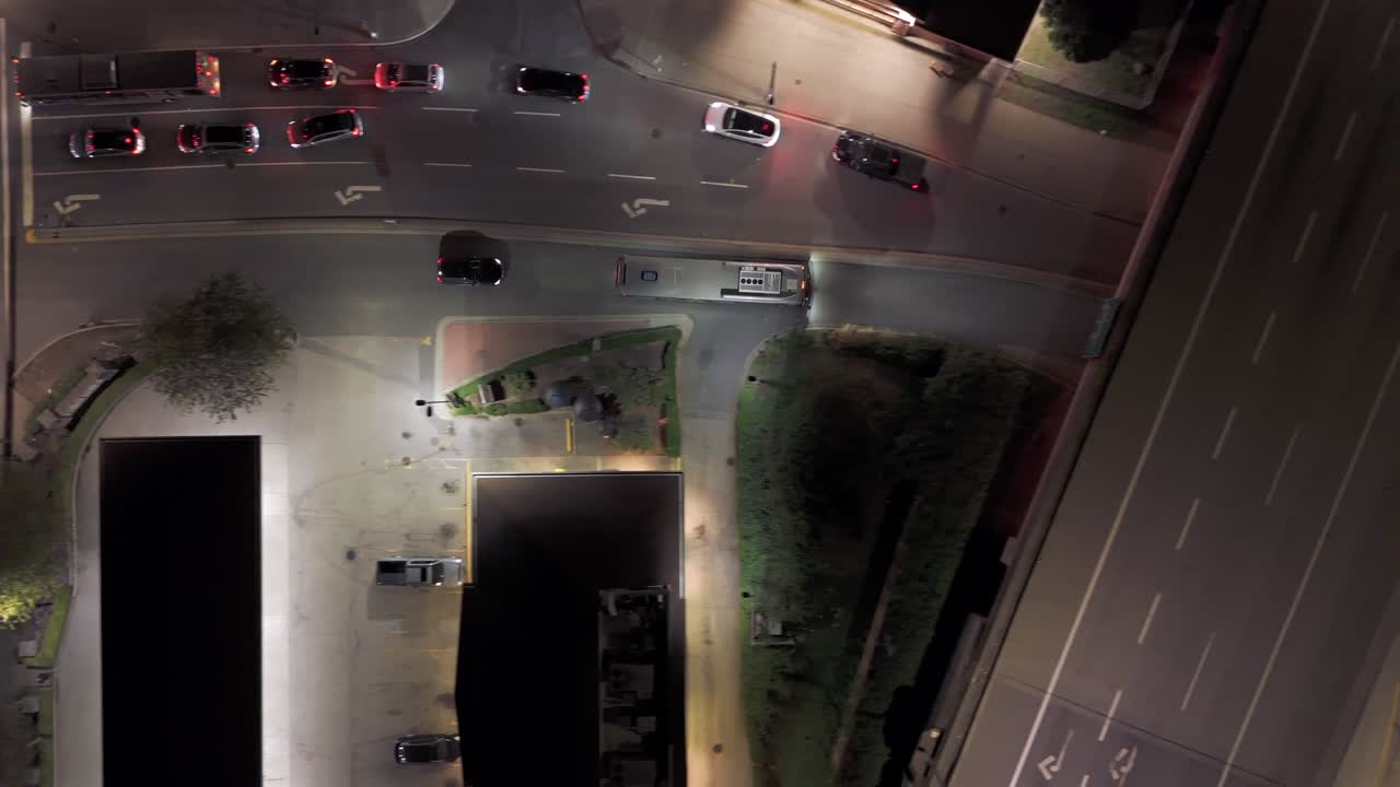 Vista aérea vertical superior descendente - Autobús circulando con seguimiento nocturno