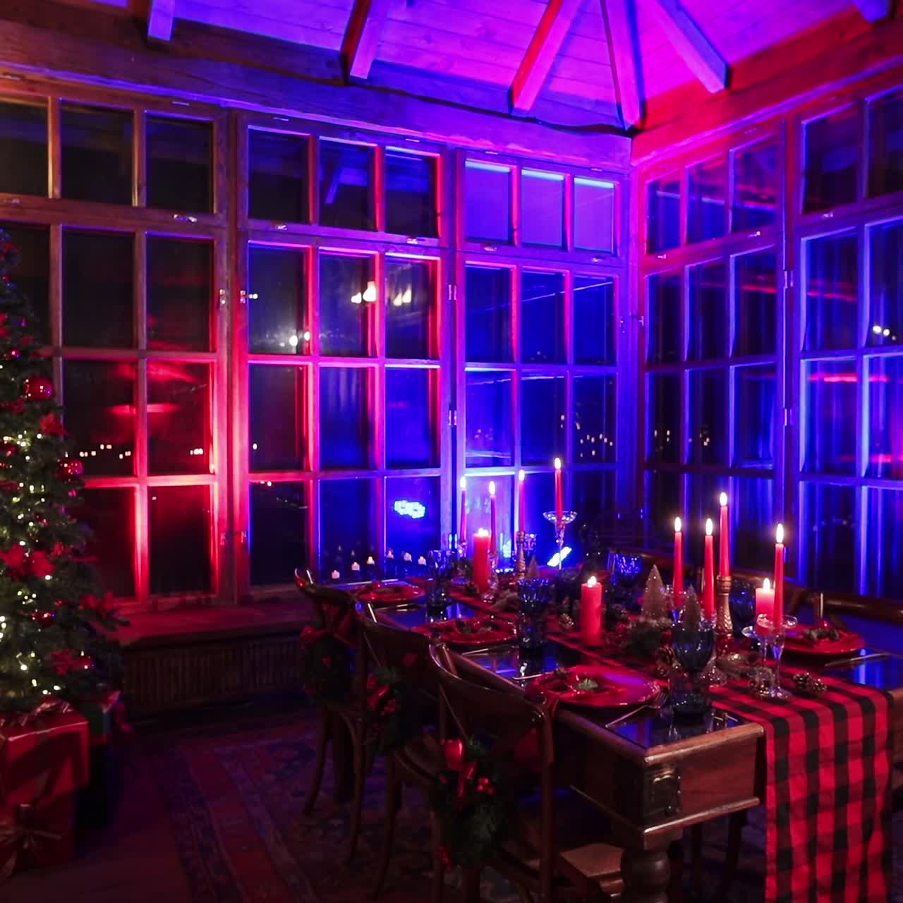 Wonderful festive room with red and blue lights. Old manor hall with beautifully laid table and Christmas tree