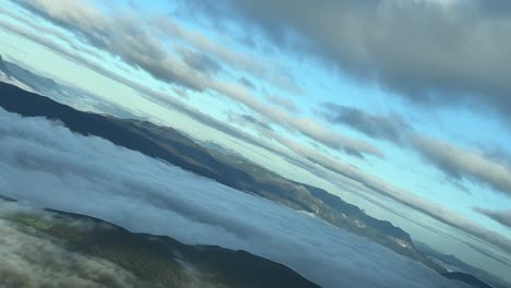 Aerial-view-shot-from-an-airplane-cabin-of-a-foggy-mountain-valley-near-Pamplona-city,-Spain