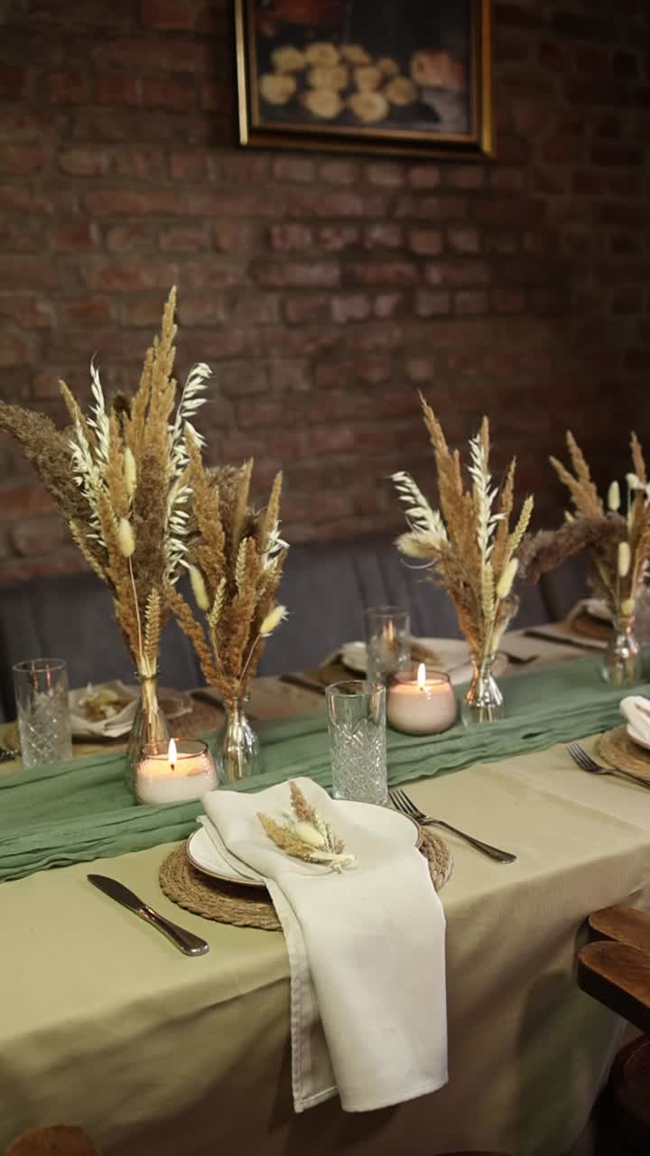 Mesa de comedor elegante con hierba de las pampas seca y velas encendidas