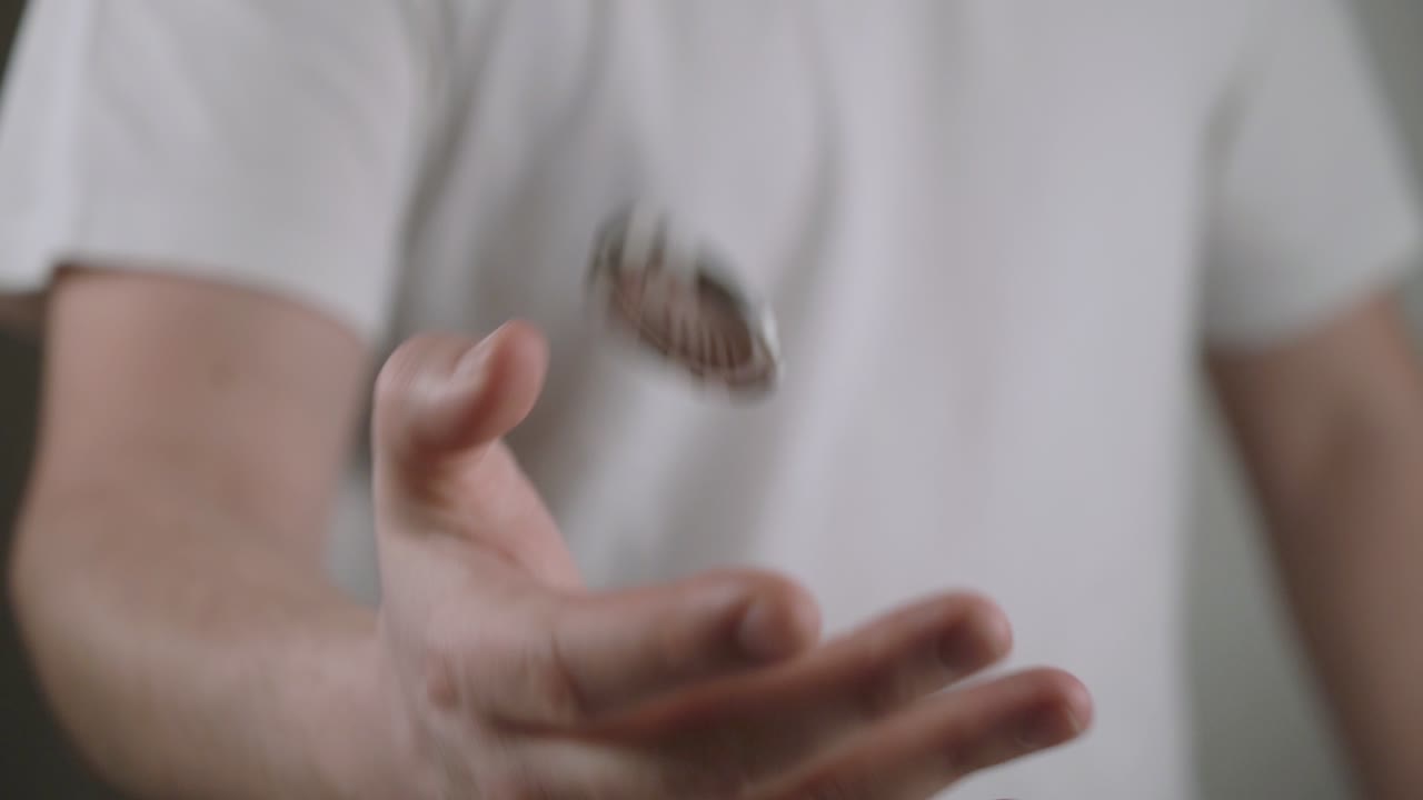 사람은 그의 손에 덜 높은 공중에 하나의 토큰을 플립