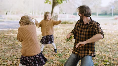 vista de la mano de la familia jugando con hojas de otoño