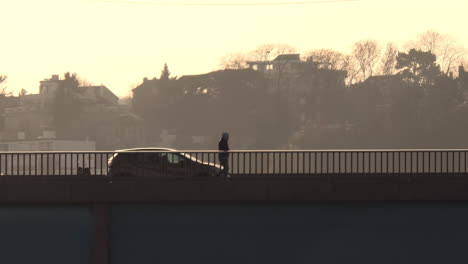 puente con autos y personas al amanecer en europa