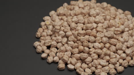 dry raw uncooked chickpeas legumes rotating on black background