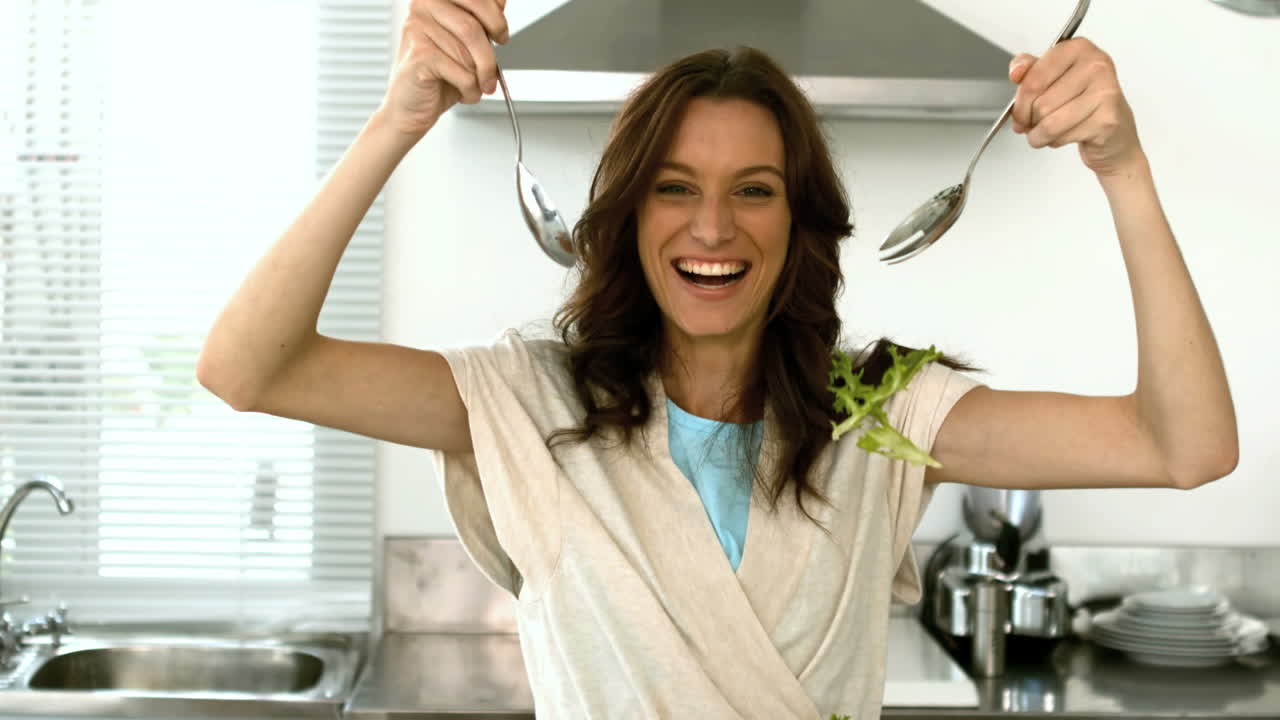 Donna che fa cadere la lattuga mentre prepara un'insalata