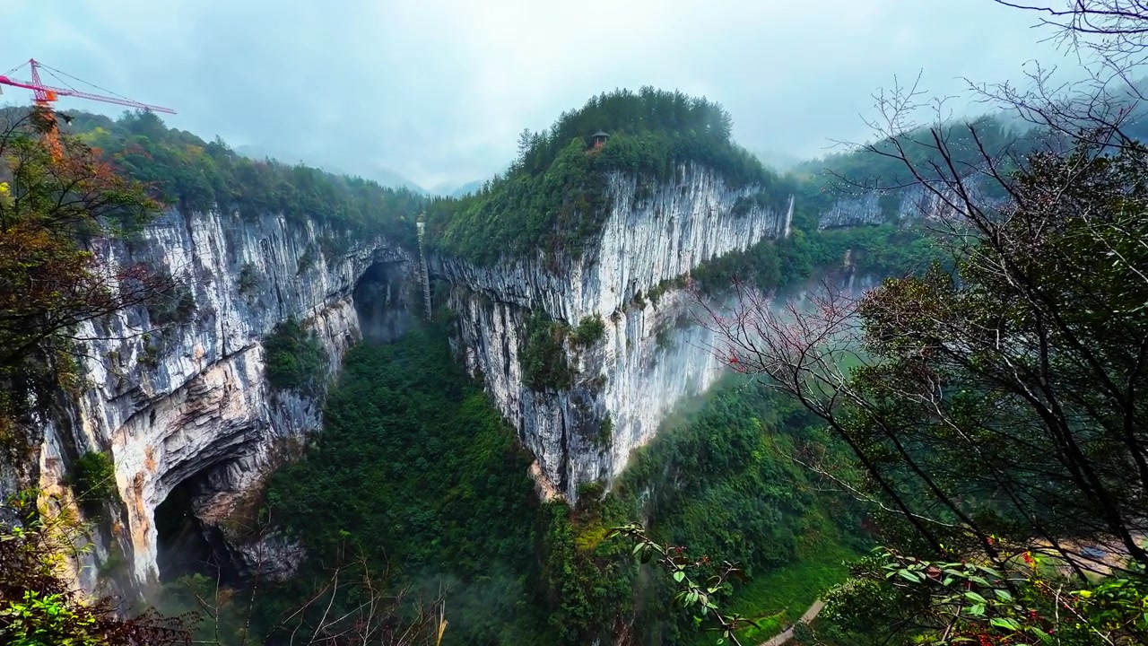 Tebing Karst Curam dan Vegetasi Hutan Hujan Lebat di Area Pemandangan Tiga Jembatan Alami, Distrik Wulong, Tiongkok. Rekaman Dongak.