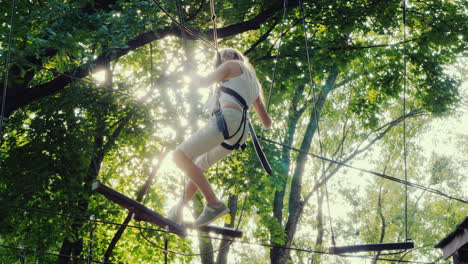 a brave child walks along a tightrope between tall trees active childhood and fun