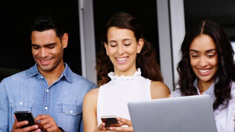 ejecutivos felices usando tabletas digitales, portátiles y teléfonos móviles