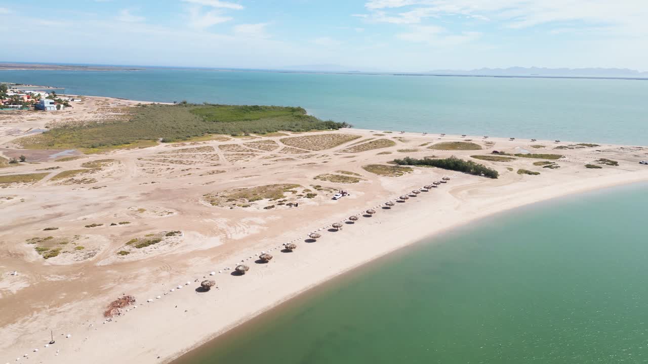Secluded beach curve with umbrellas at El Centenario, La Paz, Baja California Sur