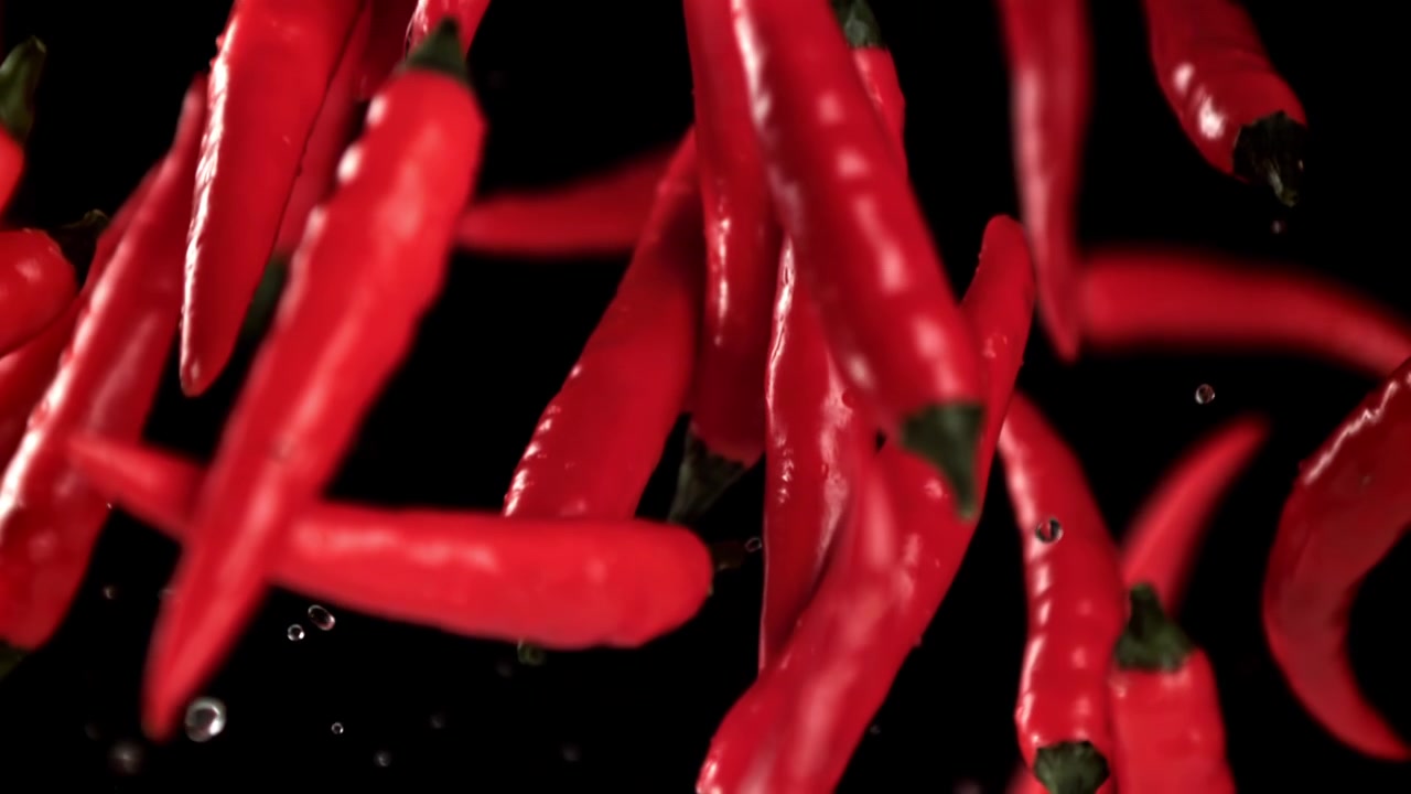 Vibrant Red Chili Peppers Falling in Slow Motion with Water Drops