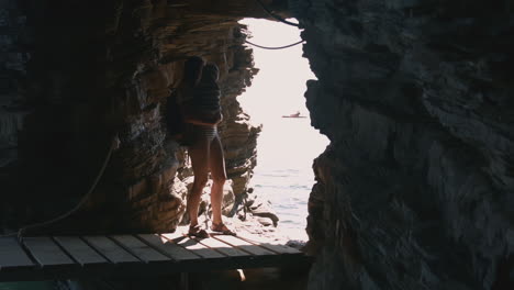 woman exploring a coastal cave