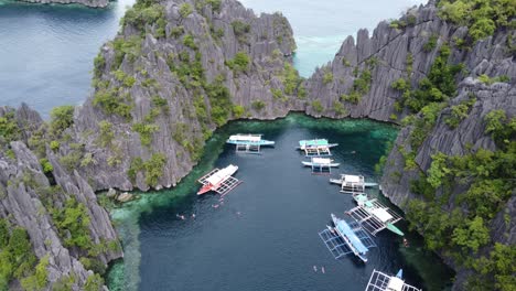 Menschen-Und-Inselhüpfer-Tourboote-Im-Klaren-Blauen-Wasser-Der-Twin-Lagoon,-Coron