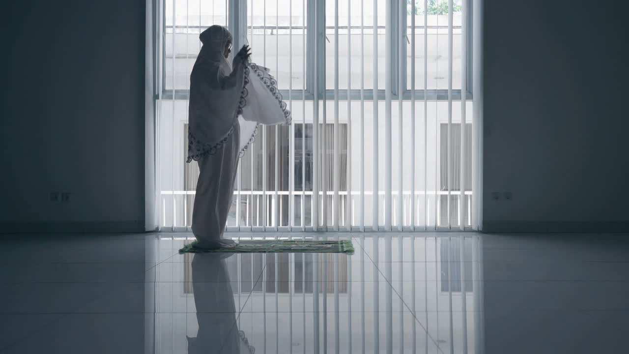 창문 근처에서 사라트를 하는 고위 여성의 측면 뷰