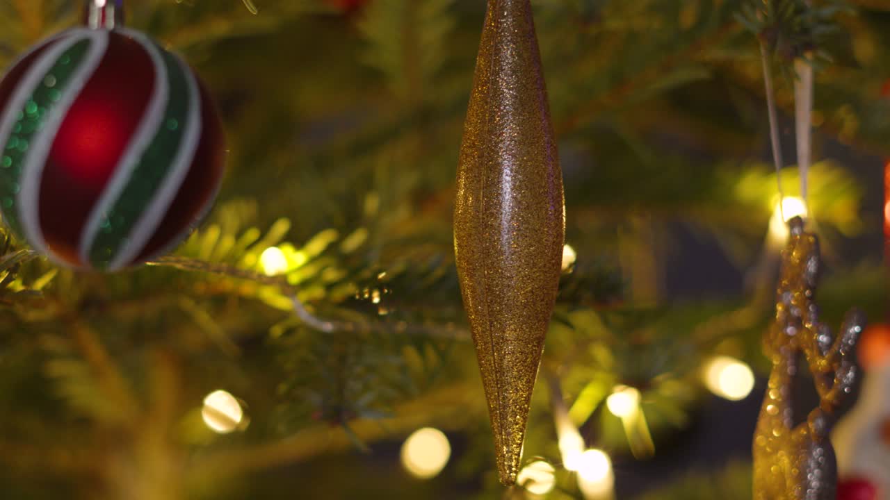 Sideways Shot of Christmas Fir Tree with Ornaments including Bourballs and Xmas Lights on Branches. Holidays Seasonal Footage 4K Video Background.