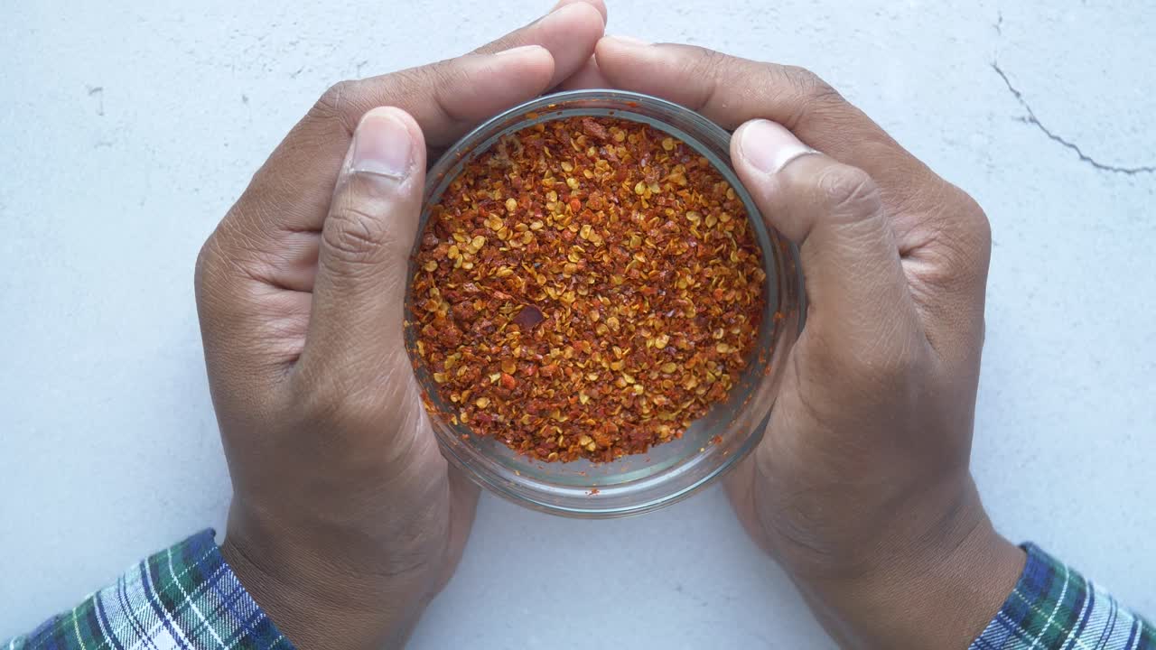 손은 칠리 플레이크의 그을 들고 있습니다.