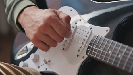 the hands of an unrecognizable man learning to play the electric guitar