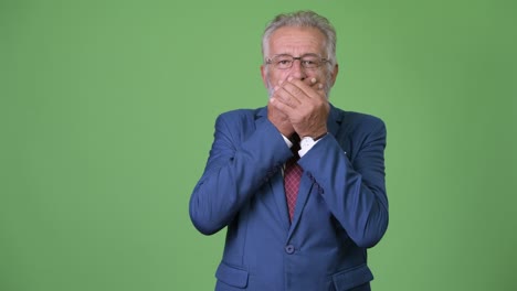hombre de negocios barbudo y guapo contra un fondo verde.
