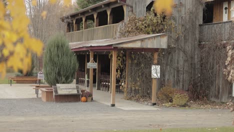 rustikaler alter hölzerner hochzeitsscheunen-zeremonieort im herbst mit gelben blättern im vordergrund auf der bean town ranch in ottawa