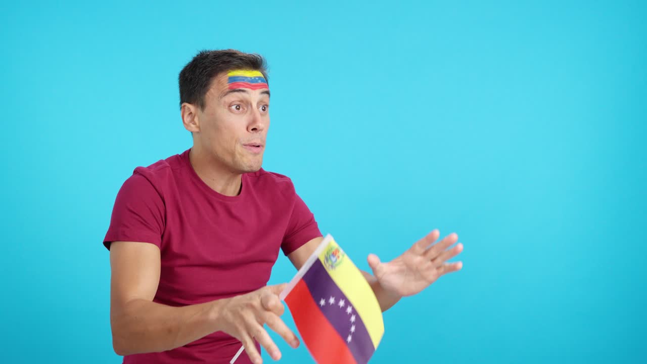 Uomo che esulta per il Venezuela sventolando una bandiera nazionale e guardando altrove