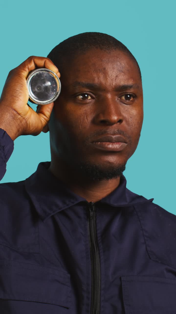 Man Holding Flashlight to Head as Light Turns On and Off