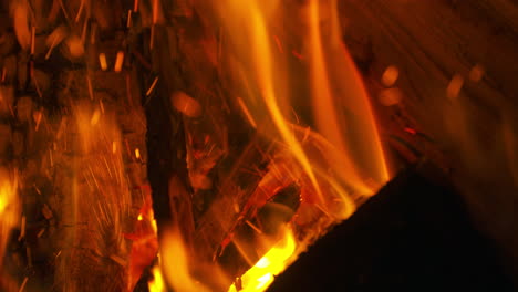 a wood log is placed into the flames of a hot fire