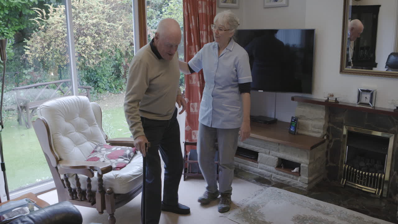 Senior man assisted by nurse in living room