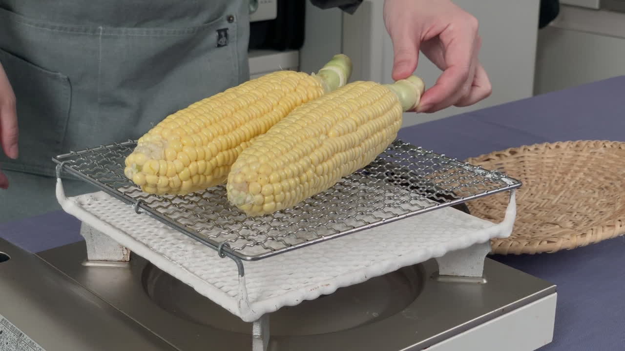 a Japanese female chef puts corns on gridiron at her home kitchen, Tokyo, Japan
