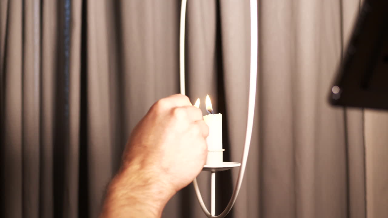 la mano masculina enciende una vela ceremonial con el golpe de un fósforo