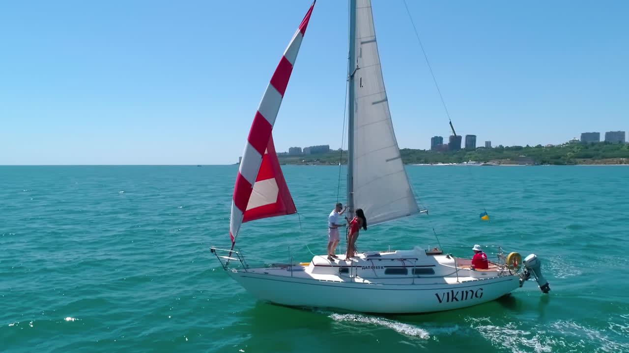 Young group of people dancing at the yacht. Aerial view of yacht holding at the sea.