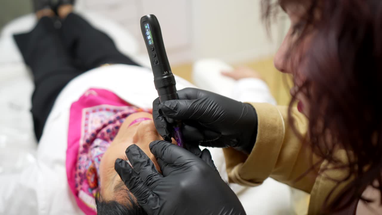 Woman Receiving Permanent Eyebrow Makeup Procedure in Beauty Salon