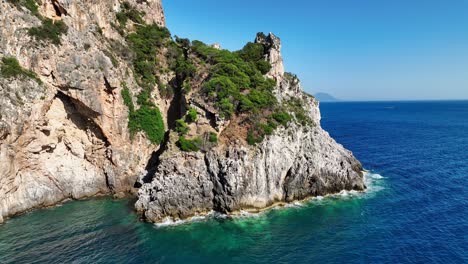 Vista-Del-Acantilado-En-La-Isla-De-Corfú-Con-Exuberante-Vegetación-Con-Vistas-Al-Mar-Jónico-Bajo-Un-Cielo-Azul-Claro