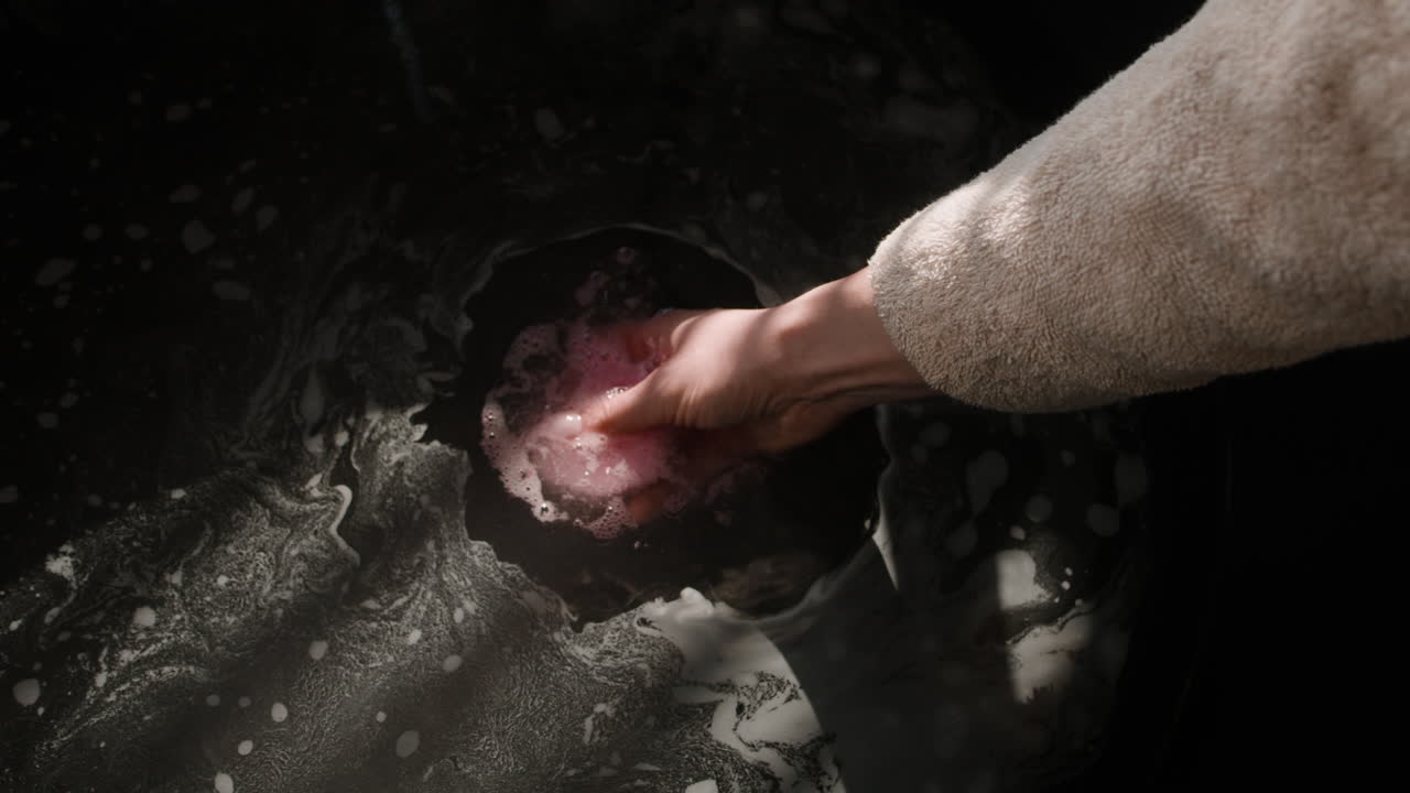Woman washing with a pink bath bomb