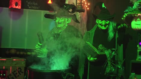 footage in a a haunted house during halloween of two mechanical witches making a potion