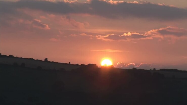 Animazione di linee bianche a zigzag su un paesaggio rurale idilliaco al tramonto
