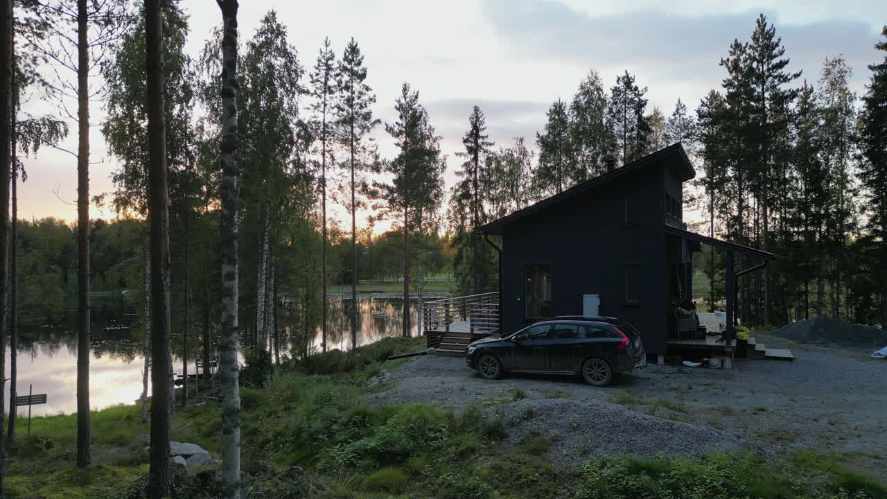 Nordisk sommerhytte og solnedgang over sø, nordisk ferie