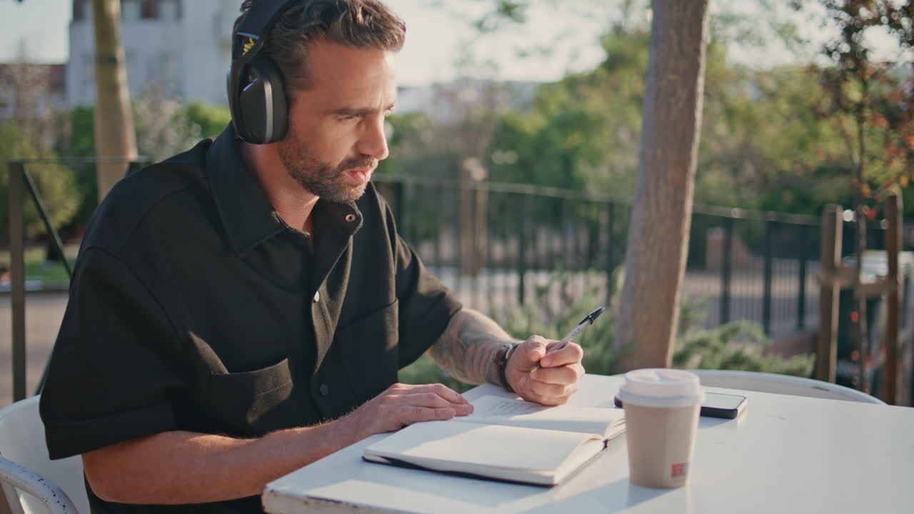 Adult student listening headphones webinar studying street cafe alone close up