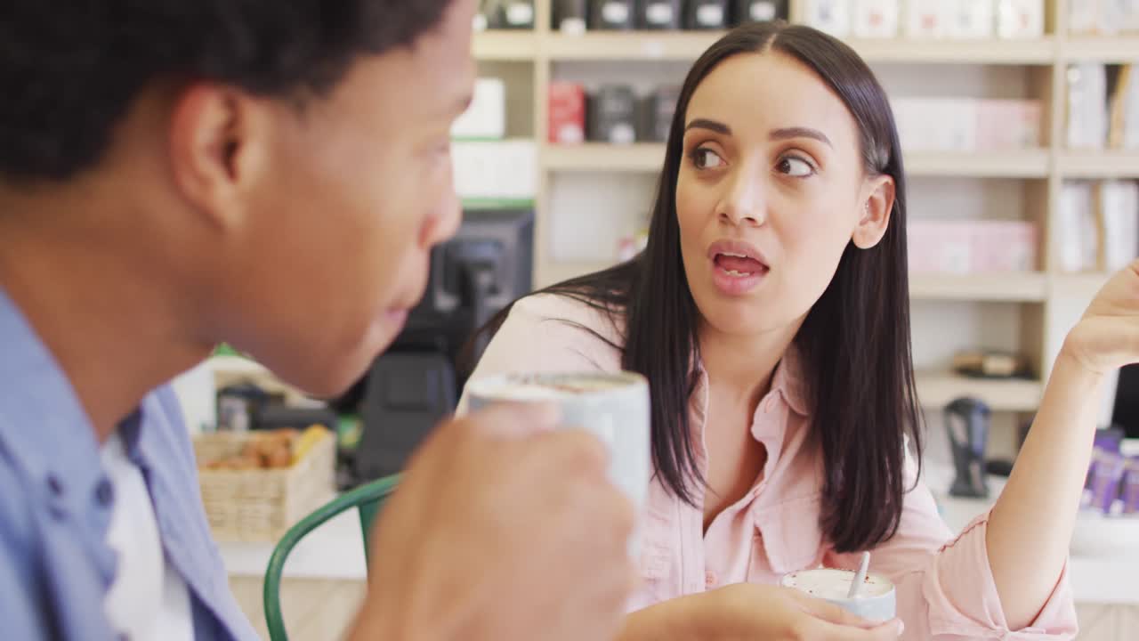 video de una mujer y un hombre felices y diversos bebiendo y hablando en una cafetería