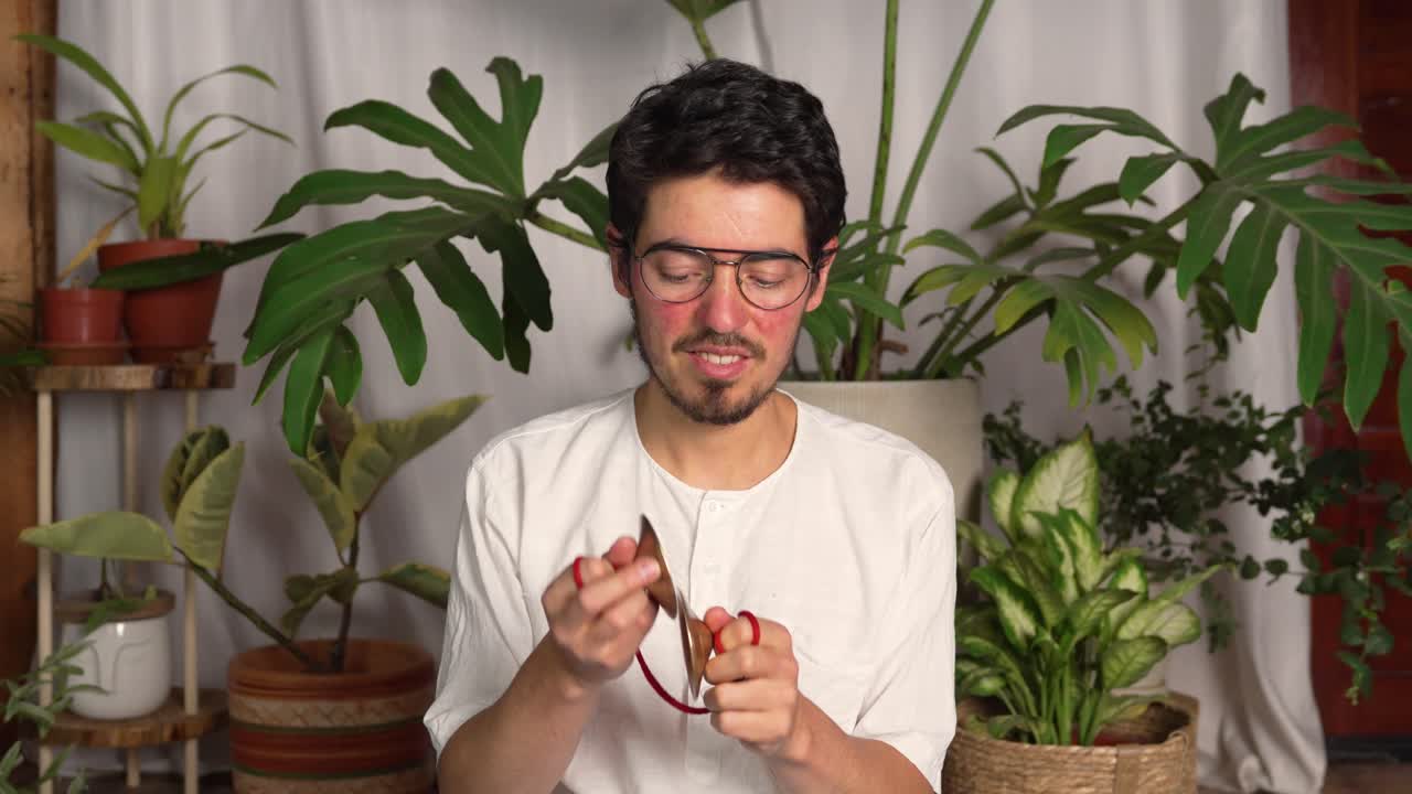 전통적 인 힌두 음악 악기 인 카르탈로스 를 연주 하는 젊은 남자