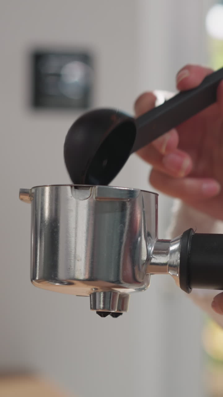 женщина добавляет кофейный порошок в портафильтр. леди наполняет контейнер порошком эспрессо, готовя сильный напиток для повышения энергии. горячий напиток для начала дня