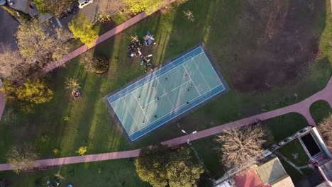 aerial top down shot of many friends playing amateur volleyball on field in park