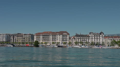 peaceful morning in geneva with the iconic jet d’eau rising from the lake, calm waters reflecting the clear sky, and the city slowly coming to life in the morning light.