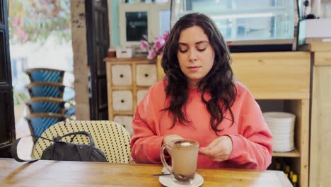 young woman adding sugar to cappuccino in cafe