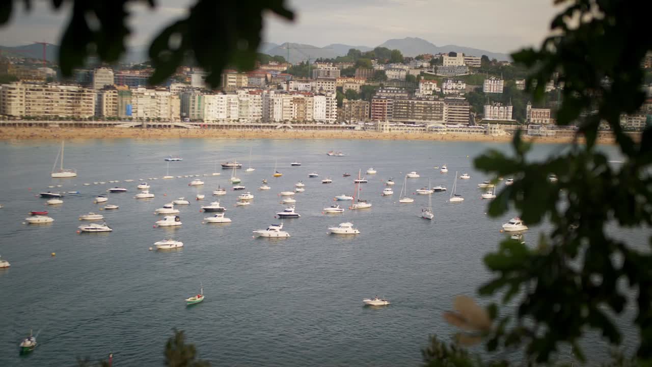 Boats on a calm harbor during sunset on a bright sunny day in San Sebastian Spain Europe by the beach, handheld shot
