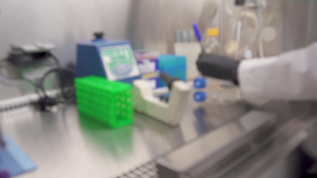 조직 배양 병에 글을 쓰는 과학자의 다른 흐릿한 클립