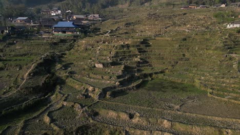 aerial drone shot flying towards layers of bright green rice terraces in the mountains of sapa, vietnam