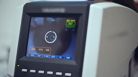 Auto refractometer testing human eye. Data screen showing progress of an eye examination. Vision concept.