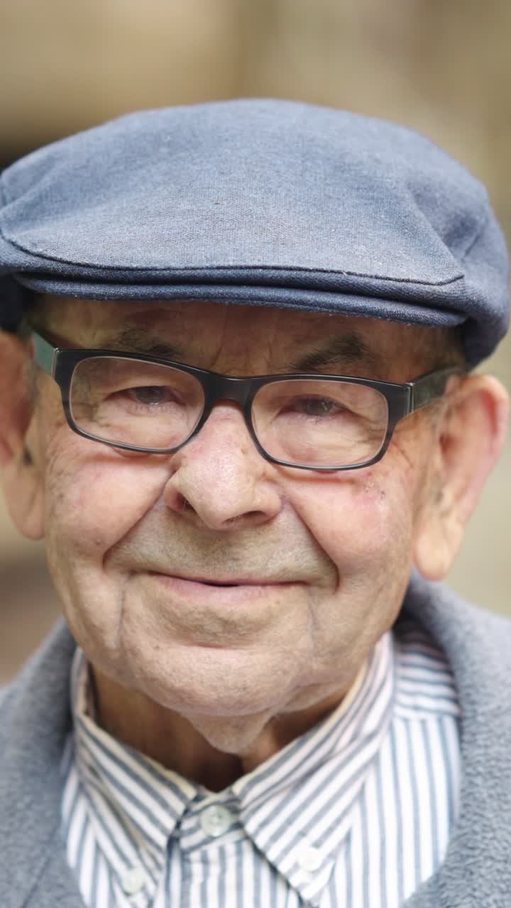 Portrait of an elderly man with glasses and a hat