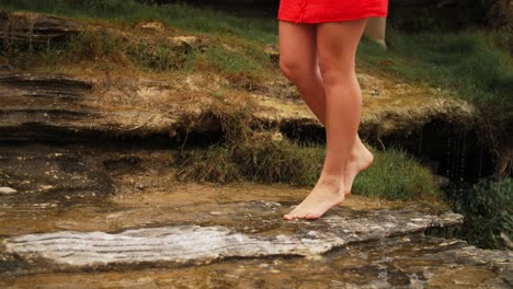 Mädchen-Im-Roten-Kleid-Auf-Zehenspitzen-Auf-Den-Nassen-Felsen-Mit-Wassertropfen-Auf-Dem-Hintergrund---Strand-In-Den-östlichen-Vororten,-New-South-Wales,-Australien