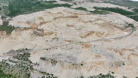 large quarry excavation on mountainside causing erosion and deforestation