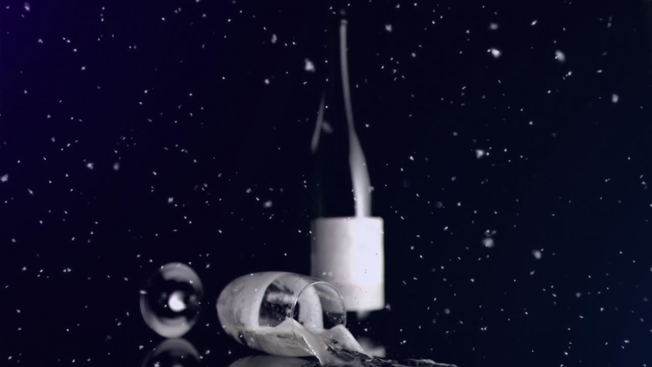 partículas blancas flotando contra un vaso lleno de champán cayendo contra un fondo negro